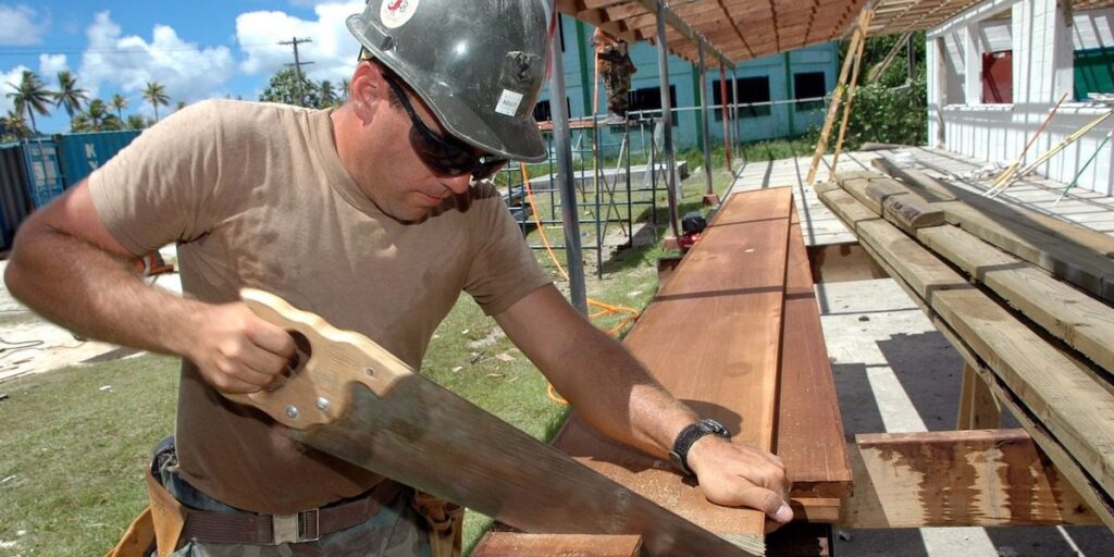 Arbeiter mit Holzbalken - Standort Arztpraxis